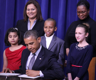 President Barack Obama signs one of 23 executive orders Wednesday. The most notable included a measure requiring federal agencies to gather more information for background checks. Children who wrote him about gun law and their parents attended the ceremony. SHFWire photo by Ian Kullgren