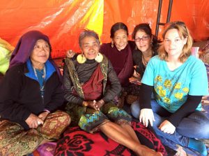 Ariela Guttin, second from the right, is pictured with another Nepal volunteer, along with several of the women now living in a tent city.