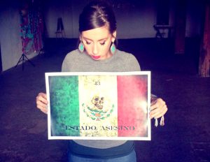 Elena Marquez holds a print by the artist Ricardo Dubby, as part of the 43+artists for 43 students project. The 11x17 prints hand signed and numbered by the artist Ricardo Duffy, will be sold to raise money for the families of Ayotzinapa.